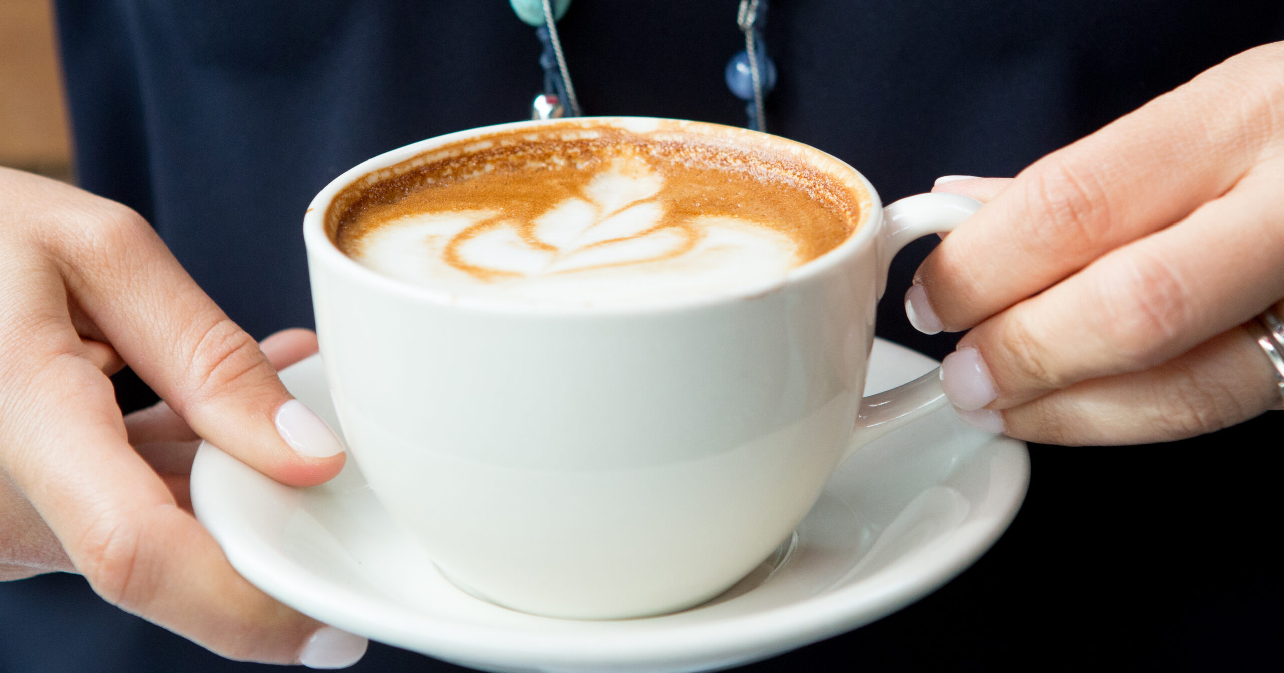 Detail shot of a white cup of espresso with a floral foam design Art Cafe Nyack, photography by Angela Gaul