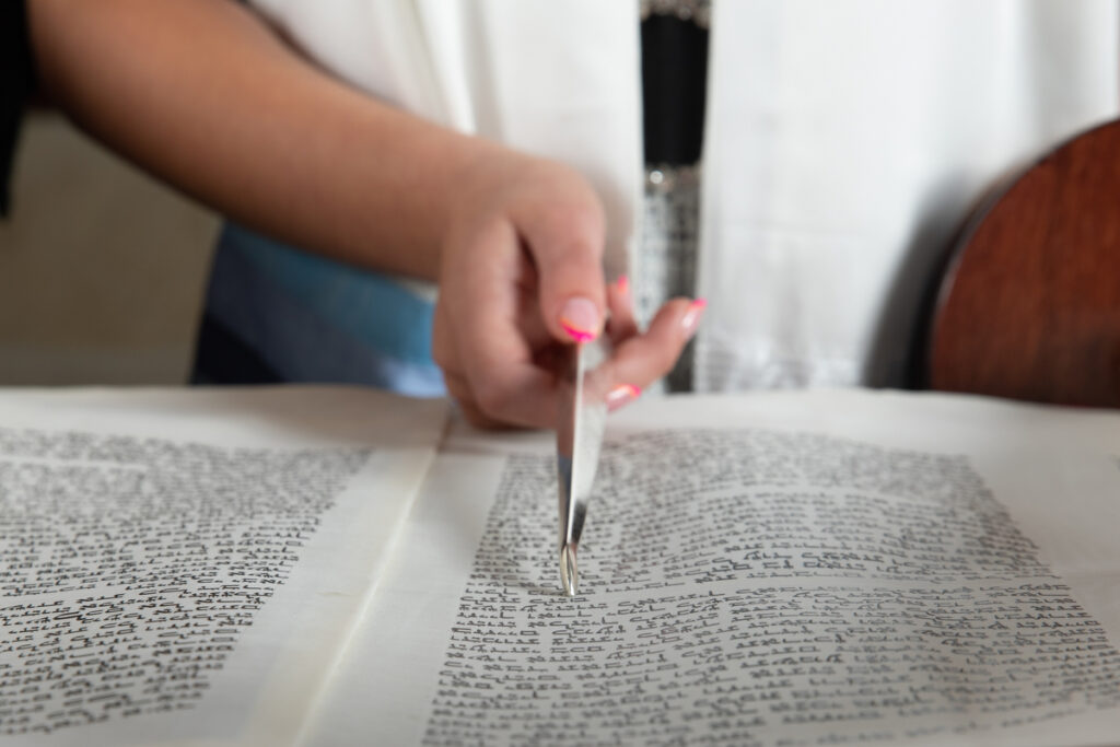 Closeup photos of a teenage girl using a yad to point to a Torah scroll at Orangetown Jewish Center Rockland County Bat Mitzvah Photographer